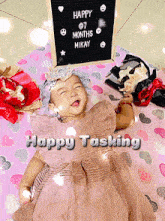 a baby is laying in front of a sign that says " happy 7 months mikay "