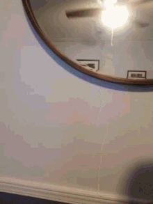 a person 's head is visible in front of a mirror with a picture on the wall