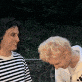 two men are standing next to each other and smiling at each other .