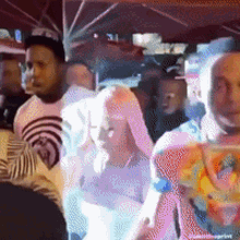 a group of people are dancing under an umbrella in a club .