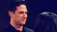 a man and a woman are looking into each other 's eyes and the woman is touching the man 's neck .