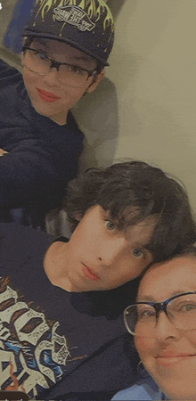 a woman wearing glasses and a boy wearing a vans hat are posing for a picture