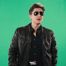 a man wearing sunglasses and a leather jacket is holding a sign that says nein on it