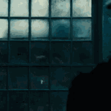 a dark room with a window that has a reflection of a person