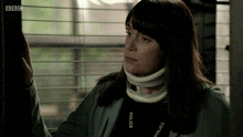 a woman wearing a neck brace and a bbc lanyard