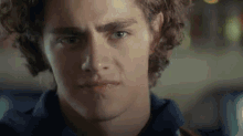 a close up of a young man 's face with a serious look on his face .