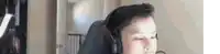 a man wearing headphones is sitting in a chair .