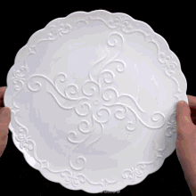 a person is holding a tortilla in front of a white plate that says mr.cakes on it