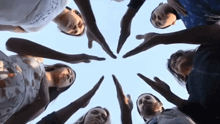 a group of people making a circle with their hands in the air