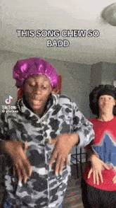 a man wearing a purple bonnet is dancing with another man in a red shirt .