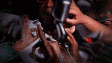a man wearing sunglasses is holding a microphone in his hand
