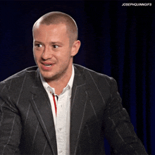 a man in a suit and white shirt with the caption josephquinngifs on the bottom