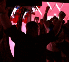 a man in a black shirt with the word tnt on it is raising his arms in the air