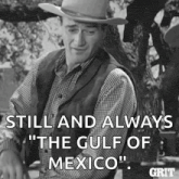 a man in a cowboy hat is standing in front of a tree .