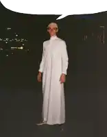 a man in a white robe is standing in front of a building that says ' dubai mall ' on it