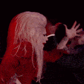 a woman in a red top is dancing with a man