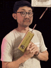 a man wearing glasses is holding a gold bar that says fire power