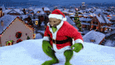 a picture of a bear dressed as santa claus with a christmas village in the background