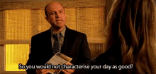 a man in a suit and tie is talking to a woman while holding a piece of paper ..