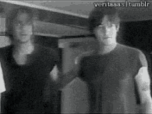 a couple of men are standing next to each other in a black and white photo .