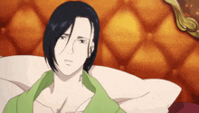 a man in a green shirt is laying down on a bed