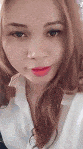 a close up of a woman 's face with a white shirt on .