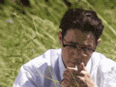 a man wearing glasses is smoking a cigarette