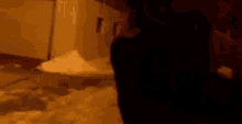 a blurry picture of a person walking down a snowy street at night .