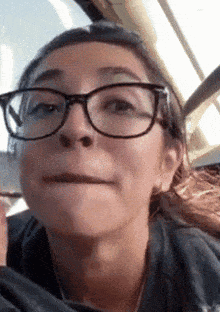 a woman wearing glasses is making a funny face
