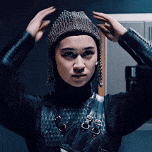 a woman wearing a knitted hat with rhinestones is adjusting it