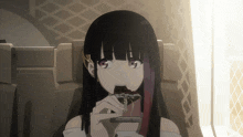 a girl with long black hair is eating a candy bar
