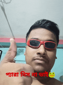 a man wearing red sunglasses giving a thumbs up sign