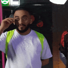a man wearing glasses and a kings t-shirt adjusts his glasses