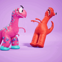 a pink dinosaur is standing next to a red toy dinosaur