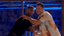 two men hugging each other in a dark room