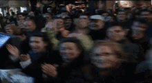 a woman wearing a scarf around her neck is smiling in front of a crowd