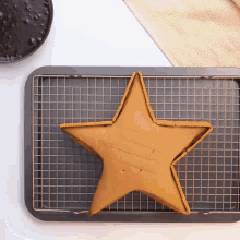 a star shaped cake is sitting on a wire rack