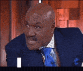 a man in a suit and tie is looking at the camera with the letter i in the corner