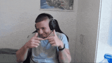 a man wearing headphones giving a thumbs up gesture