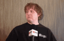 a man wearing a black shirt with a heart radio microphone