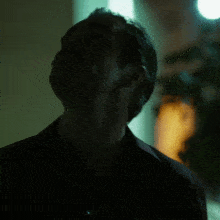 a man in a dark room looks up into the sky
