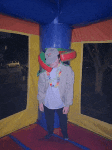 a man standing in a bouncy house wearing a hawaiian necklace