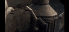a close up of a person 's hand holding a lantern .