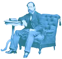 a man in a suit sits in a chair next to a small table