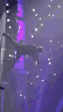a man is standing on a stage holding a microphone and a sword .