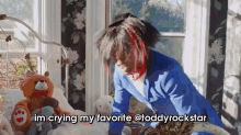a person is sitting on a bed with a teddy bear and the words im crying my favorite @teddyrockstar above them