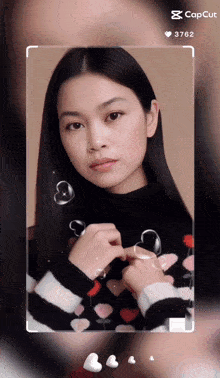 a woman in a black and white striped sweater with hearts on it is shown on a screen that says cap cut