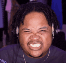 a man wearing headphones making a funny face with his mouth open