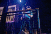 a man is standing on a balcony at night holding a light