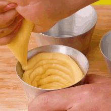 a person is pouring a yellow liquid into a cup
